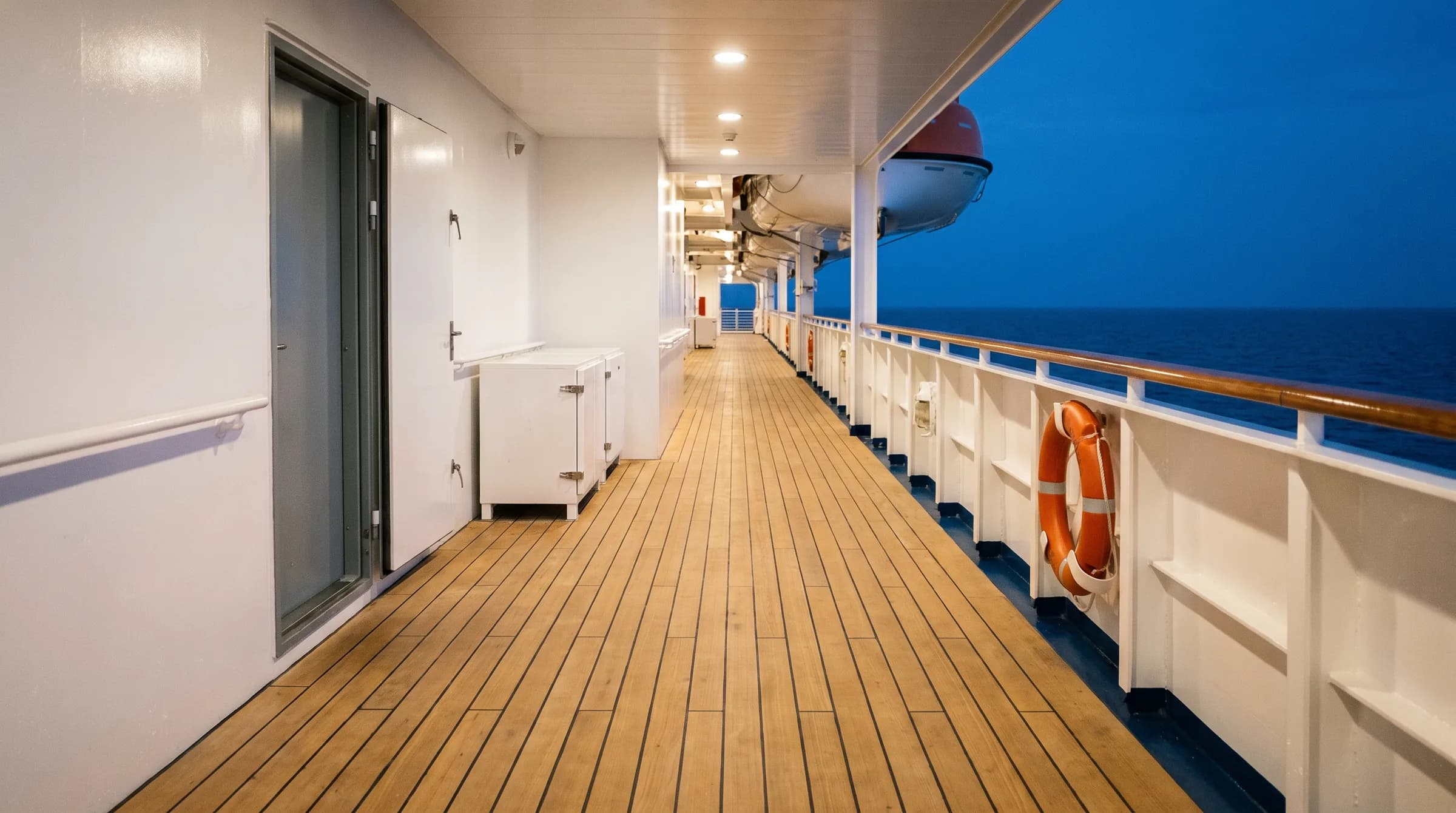 A ship's outer deck with a lifejacket locker, a watertight door and a lifebuoy on the rail